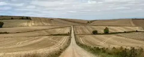 Feldweg auf dem Jakobsweg unter weitem Himmel